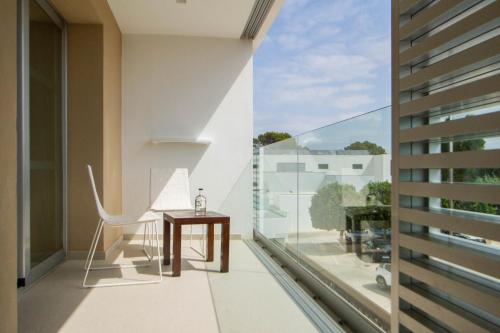 a balcony with a table and a chair on a balcony at Hotel Cala Saona & Spa in Cala Saona