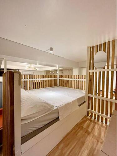 a bedroom with a large bed in a wooden frame at JORA LOFT - Japandi inspired apt 1- D in Dagupan