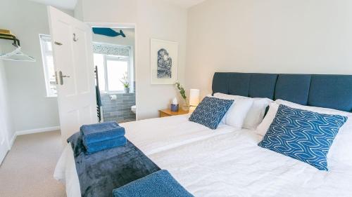 a bedroom with a large bed with blue pillows at Noddfa in Menai Bridge