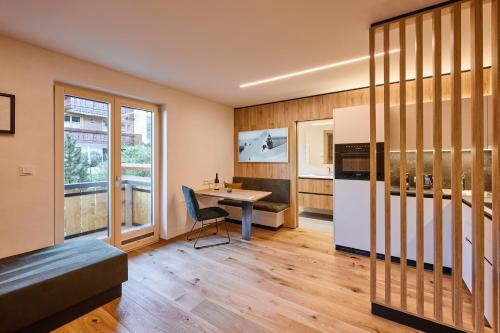 a living room with a table and a refrigerator at Appartements Täli in Lech am Arlberg
