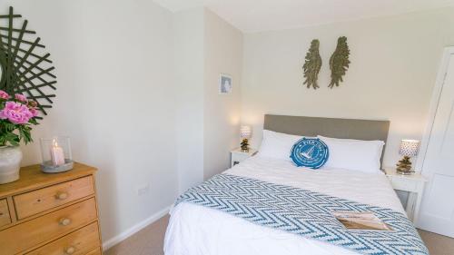 a bedroom with a bed with a blue and white comforter at Noddfa in Menai Bridge