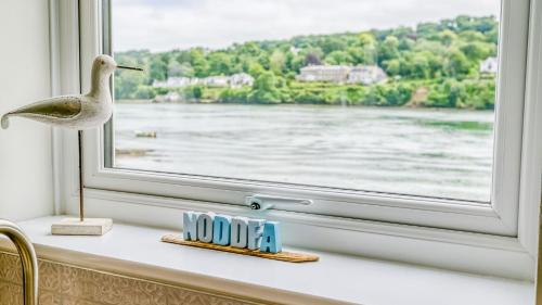 a window sill with a seagull figurine and a clock at Noddfa in Menai Bridge