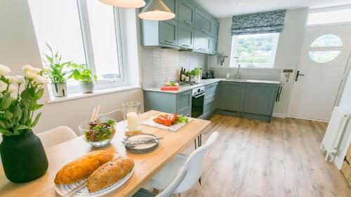 a kitchen with a table with bread and vegetables on it at Noddfa in Menai Bridge