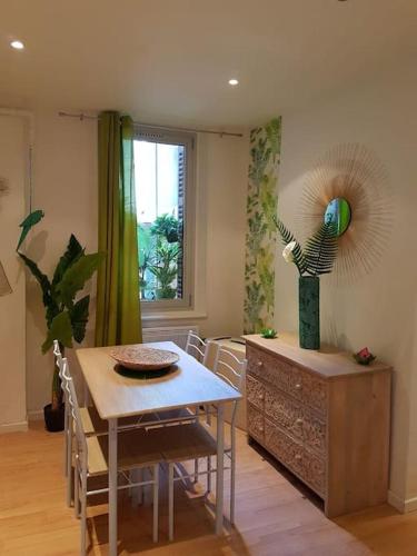 une salle à manger avec une table et un vase dans l'établissement Rêve de coco, le port à pied, à Sanary-sur-Mer