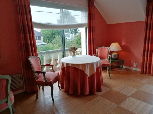 Zimmer mit einem Tisch, Stühlen und einem Fenster in der Unterkunft Les Résidences du Moulin in Téteghem