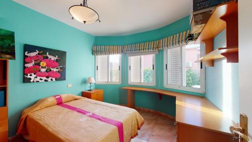 a bedroom with a bed with blue walls and windows at Bellavista in San Bartolomé de Tirajana
