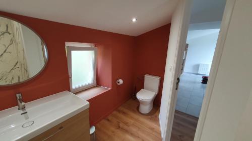 une salle de bain avec toilettes, lavabo et miroir dans l'établissement Appartement au calme, à Bournezeau