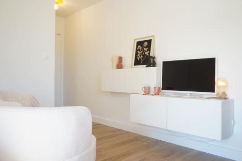 een witte woonkamer met een tv aan een witte muur bij Studio terrasse Parking CLIM sans vis à vis in La Grande-Motte