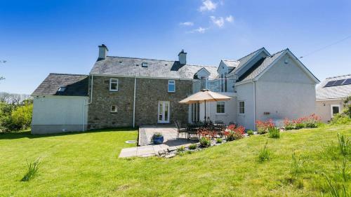 a large house with an umbrella in a yard at Pen y Fan Bellaf in Llanddyfnan