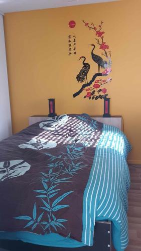 um quarto com uma cama com pássaros na parede em chambre sur Muret em Muret
