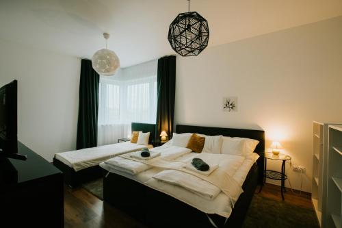 1 dormitorio con 1 cama grande y toallas. en Erzsébet Vendégház Mórahalom, en Mórahalom