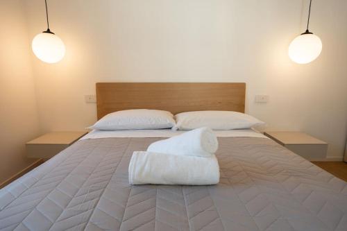 un grande letto con due cuscini bianchi di Modern Apartment Lungolago di Como a Como