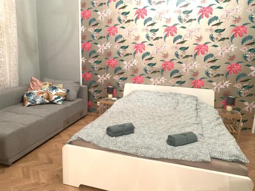 ブダペストにあるRoyal Apartmentの白いベッドと花の壁紙が備わるベッドルーム1室が備わります。