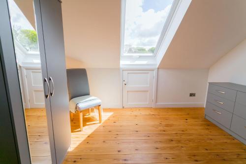 an attic room with a skylight and a wooden floor at Pant yr Afallen in Llanallgo