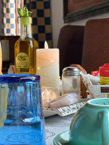 una mesa con un frasco de cristal azul y una vela en Hotel Rural Convento Santa Maria de la Sierra en Arroyo Frío