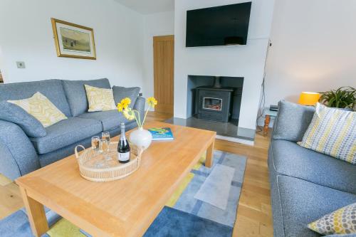 a living room with a couch and a coffee table at Pant yr Afallen in Llanallgo
