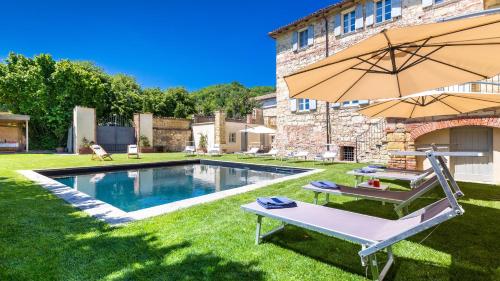 a backyard with a swimming pool and an umbrella at PALAZZO POZZO BONELLI 14, Emma Villas in Ottiglio