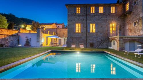 a large swimming pool in front of a house at PALAZZO POZZO BONELLI 14, Emma Villas in Ottiglio
