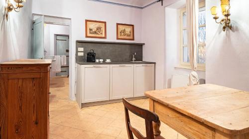 a kitchen with a wooden table and a dining room at PALAZZO POZZO BONELLI 14, Emma Villas in Ottiglio