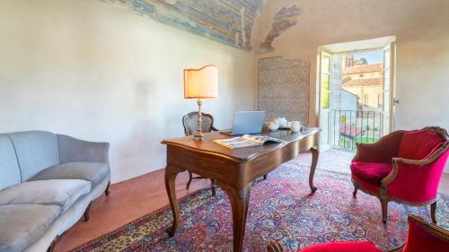 a living room with a desk with a laptop on it at PALAZZO POZZO BONELLI 14, Emma Villas in Ottiglio