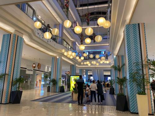 a group of people walking through a shopping mall at Classy 2BR Suite at Eastwood City with Pool and City Skyline View in Manila