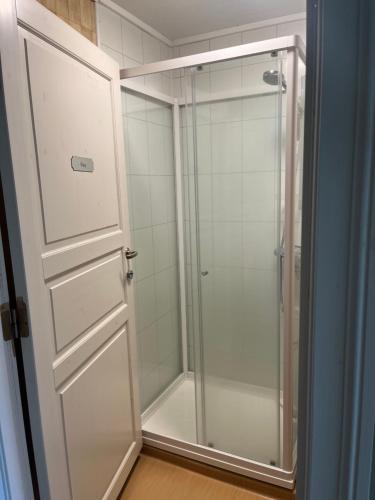 um chuveiro com uma porta de vidro na casa de banho em Visjon Gjestegård em Hokksund