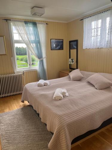 a bedroom with a large bed with towels on it at Visjon Gjestegård in Hokksund
