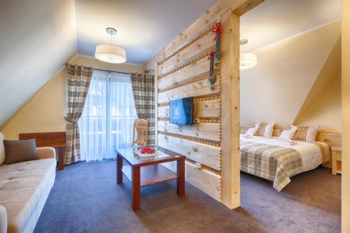 a bedroom with a bed and a table in a room at Willa Kmicic in Zakopane