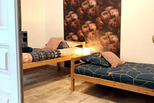 dwa łóżka w pokoju z obrazem na ścianie w obiekcie Maison chaleureuse avec son bain enchanté ! w mieście Mesnil-Saint-Père