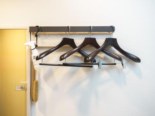 a rack of tongs hanging on a wall at Super Hotel Chiba Ekimae in Chiba