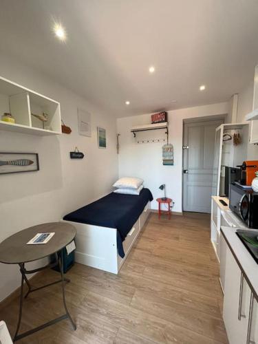 Cette petite chambre comprend un lit et une table. dans l'établissement Sanary Sunset votre cocon au coeur du port, à Sanary-sur-Mer