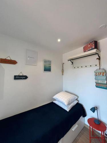 - une chambre avec un lit bleu et un tabouret rouge dans l'établissement Sanary Sunset votre cocon au coeur du port, à Sanary-sur-Mer