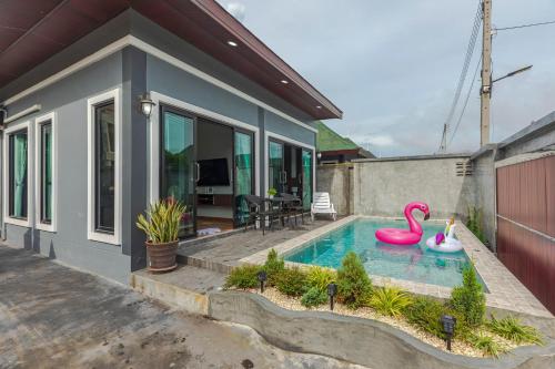 una casa con una piscina con dos flamencos inflables en N&D Poolvilla (1, 2, 3, 4), en Ao Nang Beach