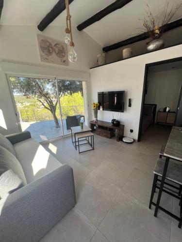 ein Wohnzimmer mit einem Sofa und einem Tisch in der Unterkunft Mini Villa 30 m2 max 4 personnes in Ensuès-la-Redonne