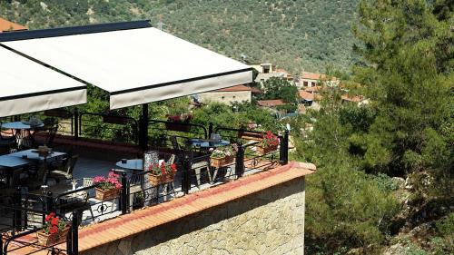 a restaurant with tables and chairs on top of a building at Kazdaglari Karye Müze Hotel in Kucukkuyu