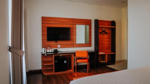 a bedroom with a desk with a television and a chair at Villa Rancabango Hotel & Resort Garut in Tarogong