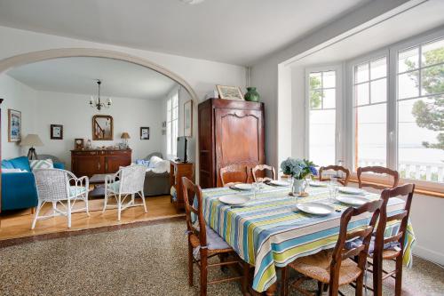 une salle à manger et un salon avec une table et des chaises dans l'établissement Maison familale au panorama de rêve, à Saint-Cast-le-Guildo