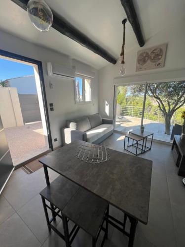 un salon avec une table et un canapé dans l'établissement Mini Villa 30 m2 max 4 personnes, à Ensuès-la-Redonne