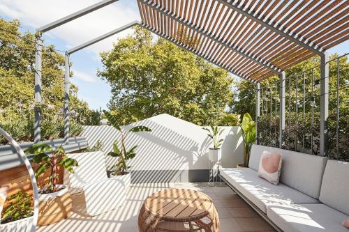 an outdoor patio with a pergola and a table at Canopy Terrace - Retreat to Voguish Urban Charm in Melbourne