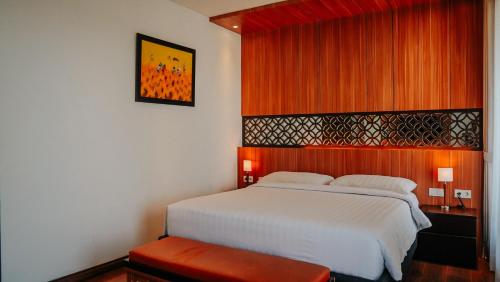 a bedroom with a white bed and red curtains at Villa Rancabango Hotel & Resort Garut in Tarogong