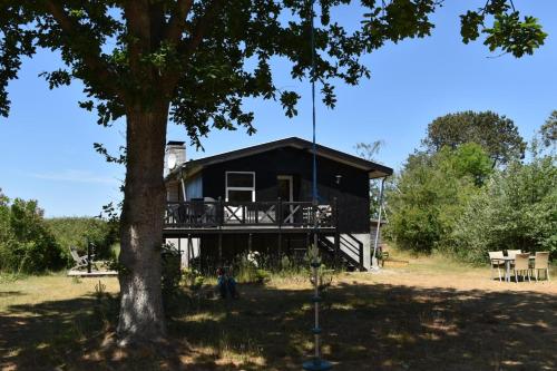 a black house with a tree in front of it at Holiday home with panoramic ocean view near Kerteminde in Martofte