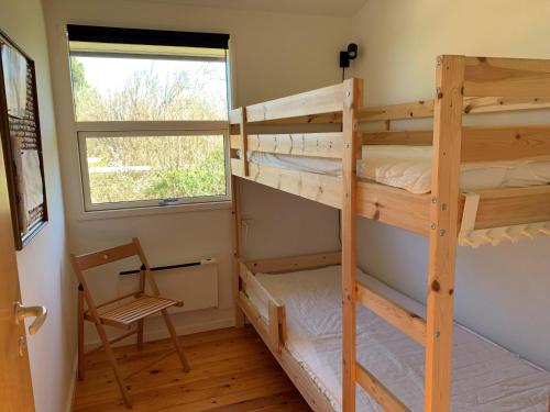 1 Schlafzimmer mit 2 Etagenbetten und einem Fenster in der Unterkunft Holiday home with panoramic ocean view near Kerteminde in Martofte