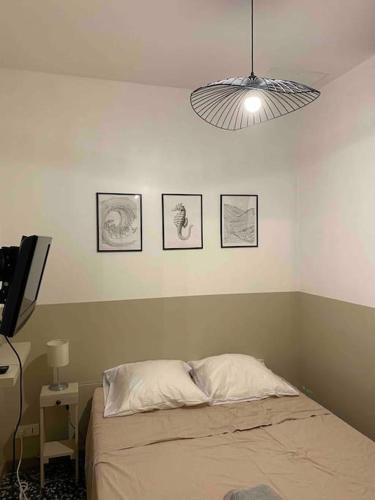 - une chambre avec un lit et trois photos sur le mur dans l'établissement Appartement au coeur du quartier de la Roquette, à Arles