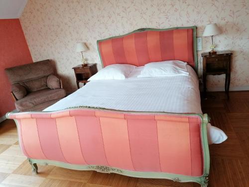 ein großes rosa Bett in einem Zimmer mit Stuhl in der Unterkunft Les Résidences du Moulin in Téteghem