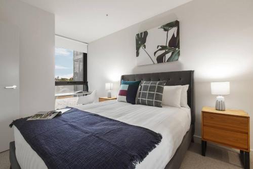 Un dormitorio con una cama grande y una ventana en Stylish and Cosy - A Mid-Century Caulfield Retreat en Melbourne