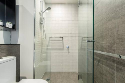 W łazience znajduje się prysznic ze szklanymi drzwiami. w obiekcie Stunning Modern Style with a Gym, Pool and Spa w Melbourne