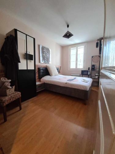 une chambre avec un lit et un parquet dans l'établissement Maison le trèfle, à Chef-Boutonne