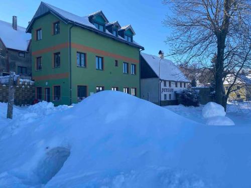 a pile of snow in front of a house at Chata Mamutka-New in Loučná pod Klínovcem