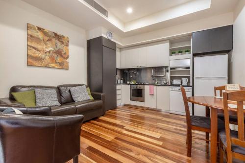 ein Wohnzimmer mit einem Sofa und einem Tisch in der Unterkunft Location meets Comfort near Bourke Street Mall in Melbourne