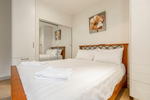 ein Schlafzimmer mit einem großen weißen Bett mit weißen Kissen in der Unterkunft Location meets Comfort near Bourke Street Mall in Melbourne